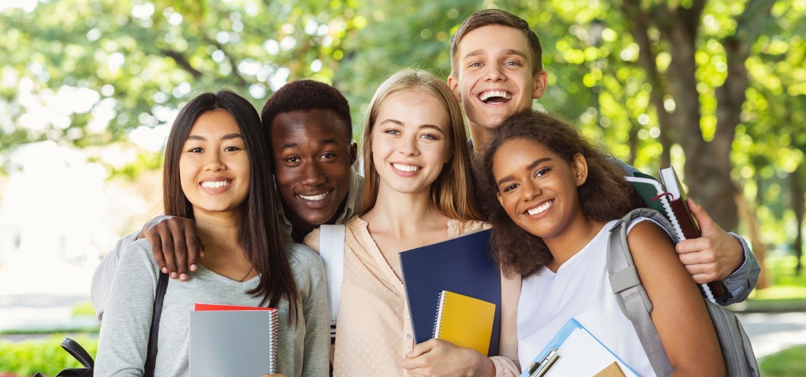 Group of five students looking at camera and smiling 